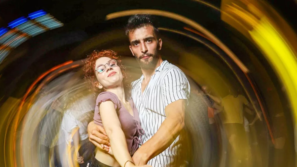 Un couple dansant tout proche dans un club faiblement éclairé, capté avec un flou de mouvement