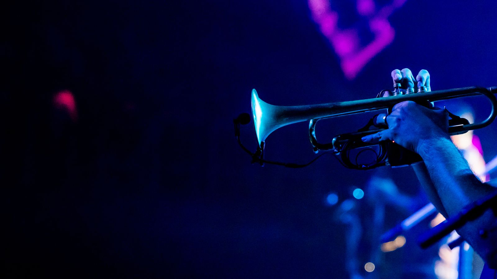 Un trompettiste joue sous les lumières chaudes de la scène lors d'un concert